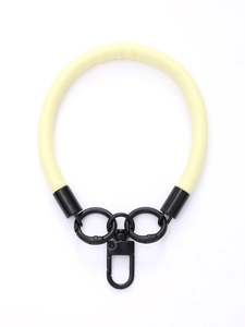 Detail of light yellow leather phone wrist strap with black metal swivel hook and rings