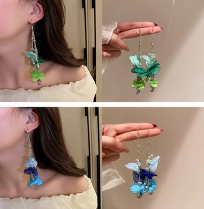 Detail of long floral tassel earrings with fabric petals and crystal beads in blue and green