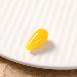Macro detail of yellow resin teardrop charm with vintage holographic effect for DIY jewelry
