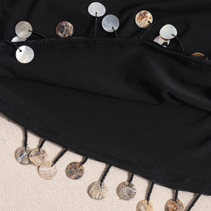 Detailed view of hand-beaded black sequins and fringed trim on a slim fit backless dress