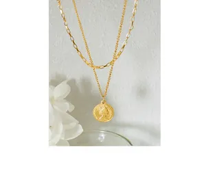 Close-up of dual-layer gold titanium necklace with vintage Queen Elizabeth coin pendant