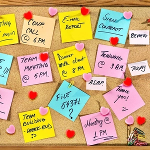 Creative heart shaped thumbtacks in red and pink colors on a wooden cork board