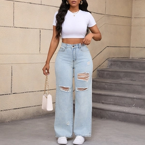 Scatto all'aperto di jeans strappati a vita alta con top bianco e borsa alla moda