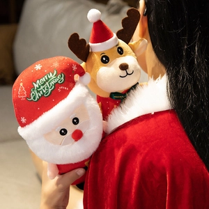 Detail of plush Santa and reindeer dolls held by a girl in a festive setting