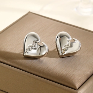 Sliver heart stud earrings with cracked texture displayed on a brown jewelry box