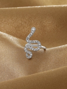 Dettaglio macro dell'anello a serpente argento con zirconi su raso color champagne