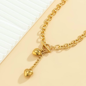 Detail of gold chunky chain necklace with heart pendant and OT toggle clasp closure