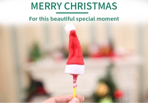 Close-up of mini red and white plush Christmas hats for cutlery and lollipop decor