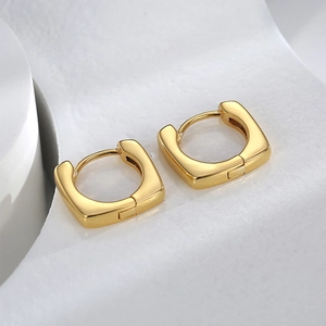 Detailed macro view of golden square hoop earrings with a polished finish and hinge closure
