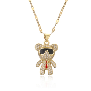 Golden bear pendant necklace with sparkling zircons, black sunglasses and red tie detail