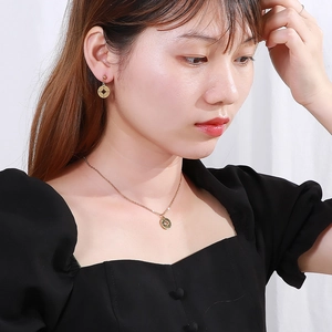 Parure collier pendentif boussole ajouré et boucles d'oreilles en acier plaqué or 18k sur mannequin