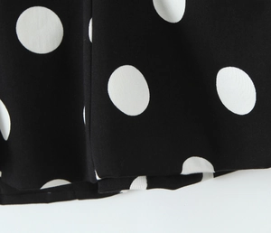Gros plan du tissu noir à pois blancs montrant la texture tissée haute densité