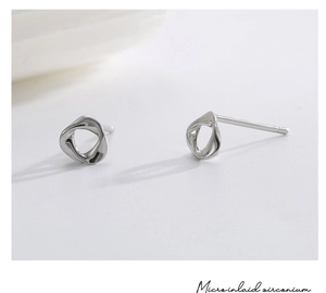 Macro shot of silver twisted studs showing micro inlaid zirconium and polished finish