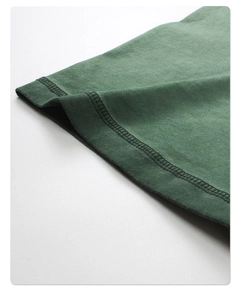 Macro shot of double-row stitching and knit cotton texture on dark green vintage t-shirt