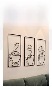 Three-piece black iron wire wall art set featuring coffee cups on white living room wall