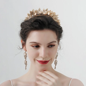 Detail of golden leaf crown with rhinestone pearl tassel earrings on elegant model