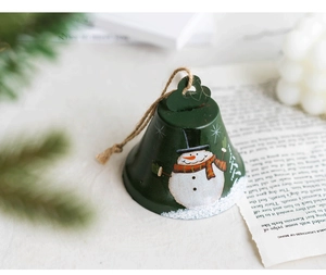 Macro view of a dark green Christmas bell with snowman pattern and jute hanging rope
