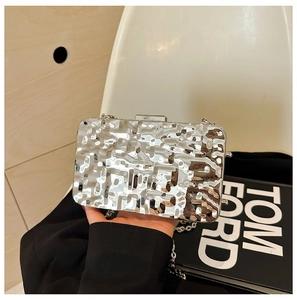 Detail of silver metallic clutch bag with hammered texture and thin chain strap