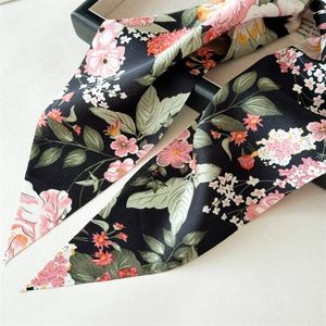 Close-up of floral print satin scarf with soft silk texture and elegant drape detail