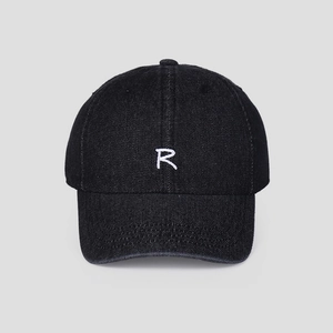 Close-up of white R letter embroidery on black denim fabric of a baseball cap