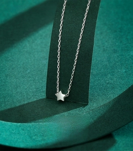Macro shot of S925 sterling silver star pendant on green velvet jewelry display