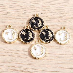 8pcs enamel star and crescent moon pendants with gold beaded edges on wooden surface