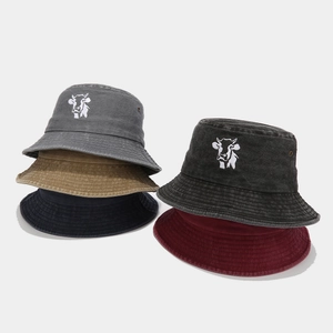 Vintage washed cotton bucket hats with cow embroidery in various colors shown stacked