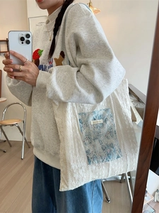 Sac fourre-tout beige en dentelle avec patch floral bleu et motifs floraux texturés