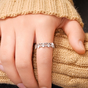 Macro detail showing heart-shaped cutout pattern and sparkling zircons on the silver ring