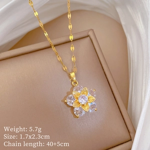 Detail of gold flower pendant necklace with white zircon on jewelry display case