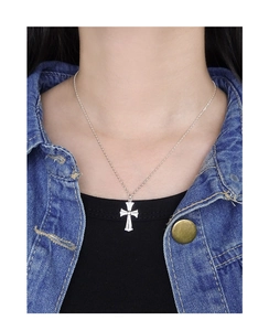 Detail of S925 sterling silver cross pendant necklace worn by a model on denim jacket