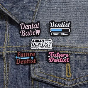 Five dental themed enamel pins including Future Dentist slogan on blue denim jacket