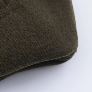 Close-up of the premium dark green wool fabric detail on a casual bomber jacket