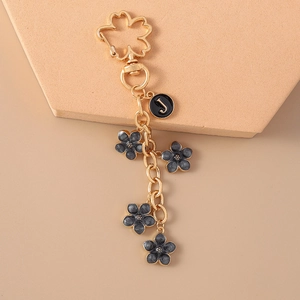 Detail of floral metal keychain with cherry blossom hook and letter J tag charm