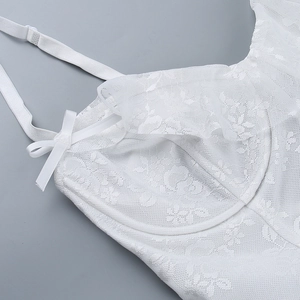Détail de la robe caraco blanche en dentelle florale avec nœud en satin et maille