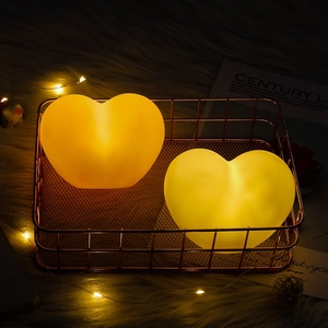 Detailed view of warm glowing heart-shaped night lights in a stylish rose gold metal basket