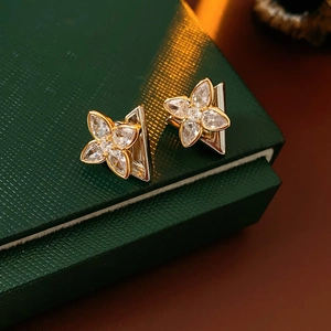 Macro view of crystal clover earrings on textured dark green jewelry gift box