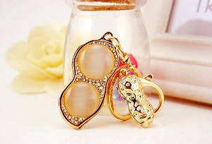 Macro shot of golden peanut keychain with sparkling rhinestones and cat eye stones
