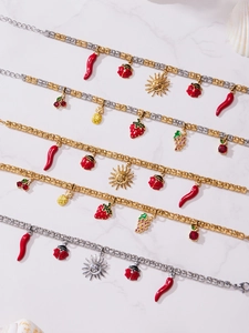 Detailed close-up of fruit and insect charms on colorful beaded bracelets with gold finish