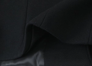 Detailed macro view of black wool coat featuring high-quality inner lining texture