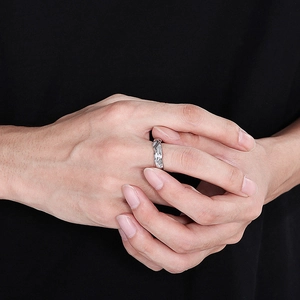Detailed close-up of a silver irregular wave ring with liquid metal texture on finger