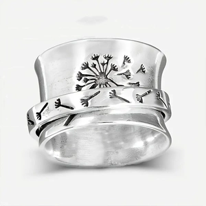 Detailed view of vintage silver spinner ring with dandelion engraving and floral patterns