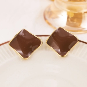 Macro detail of geometric rhombus earrings with chocolate brown enamel and gold plating