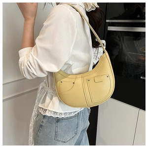 Detail of yellow hobo bag showing litchi texture and denim style pocket with studs