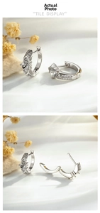 Macro detail of silver geometric huggie earrings with micro-set cubic zirconia stones