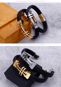 Detail of woven black leather bracelet with gold and silver industrial cross clasps