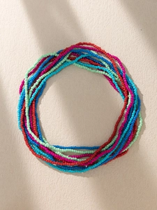 Macro shot of multi-layer colorful seed beads in bohemian style on beige texture
