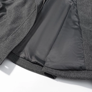 Detail of grey wool coat hem showing high-quality stitching and smooth dark inner lining