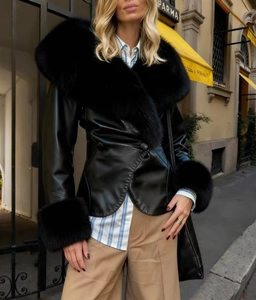 Détail d'une veste en cuir noir avec col et poignets en fourrure luxueuse dans la rue