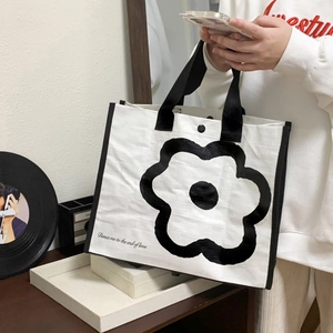 Detail of white canvas tote bag with black flower print and magnetic snap button
